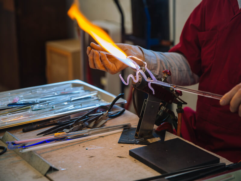 Swirly glass under a flame in a glass blowing class.